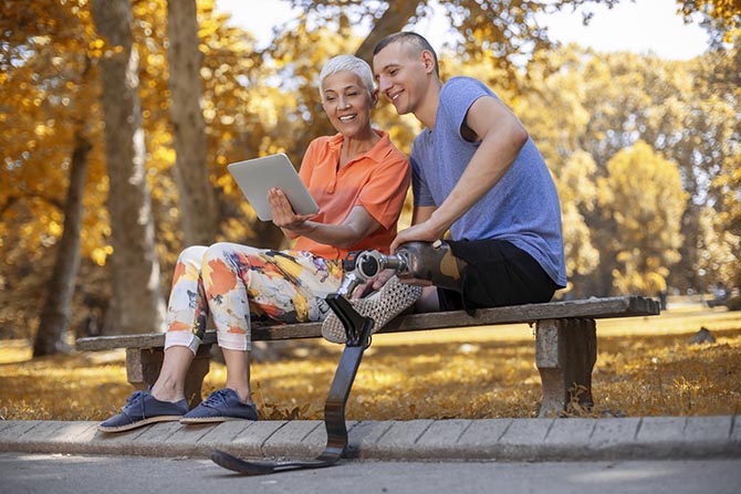 Un jeune et un adulte assis ensemble sur un banc, dehors.